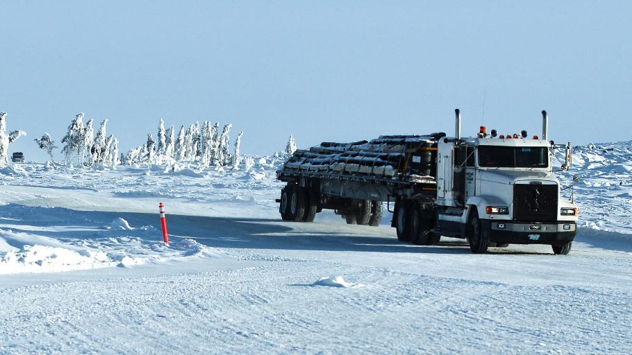 Truck driving off a portage onto a lake