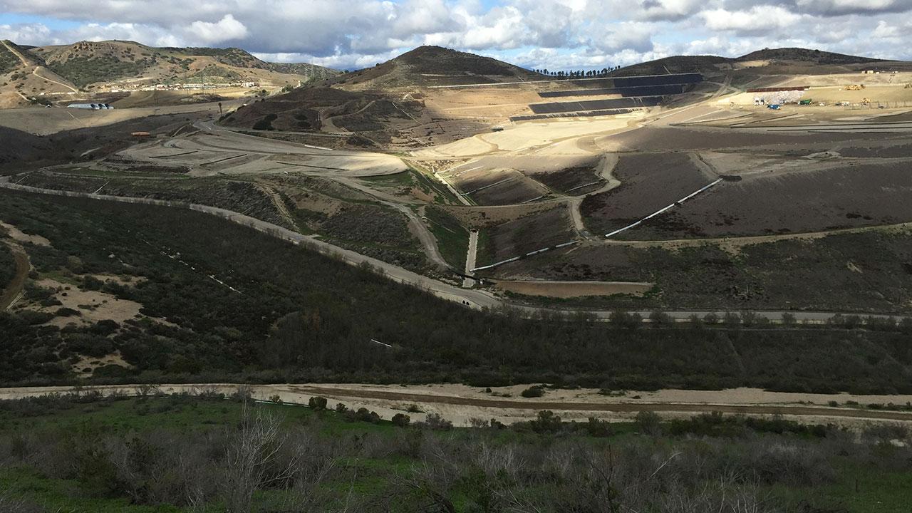 Aerial view of a landfill with clouds in the background