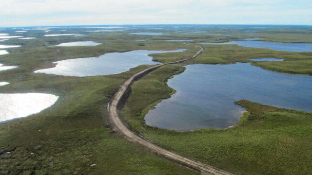 Aerial view of Inuvik Tuktoyaktuk Highway, a 140-kilometer, two-lane gravel road over complex ice-rich permafrost terrain